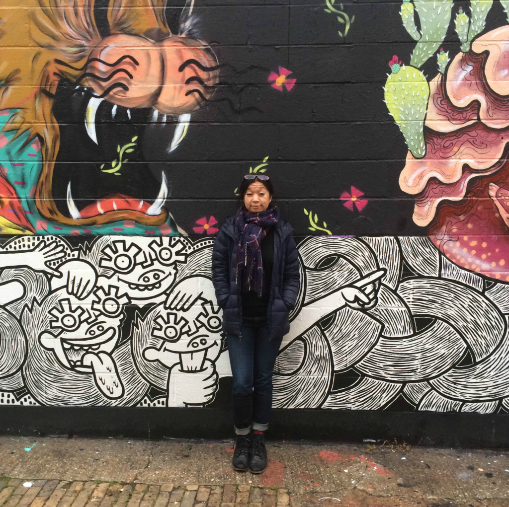 Melanie standing in front of a mural in DC.